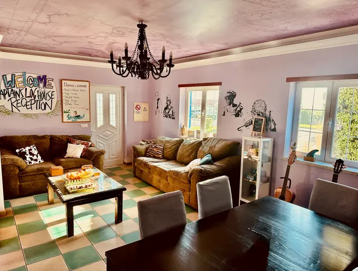 Reception lounge with lavender walls, chandelier and chequered tile floor